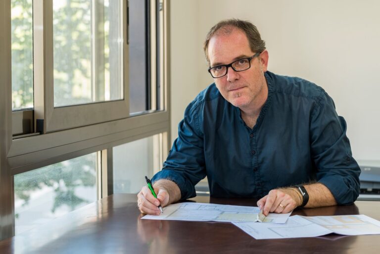 Marc Fernández sentado frente a un escritorio con planos de trabajo